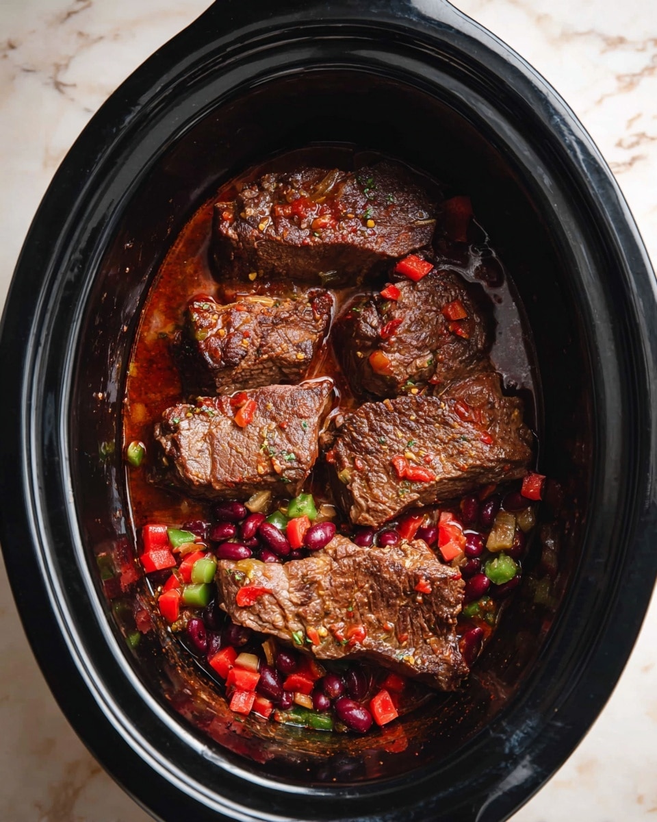 A black slow cooker filled with four large browned pieces of meat, arranged in a slightly overlapping pattern. Below the meat, a mix of small chopped vegetables, including bright red chunks, dark red kidney beans, and green pieces, sits in a reddish sauce. The slow cooker is placed on a white marbled surface. Photo taken with an iphone --ar 4:5 --v 7