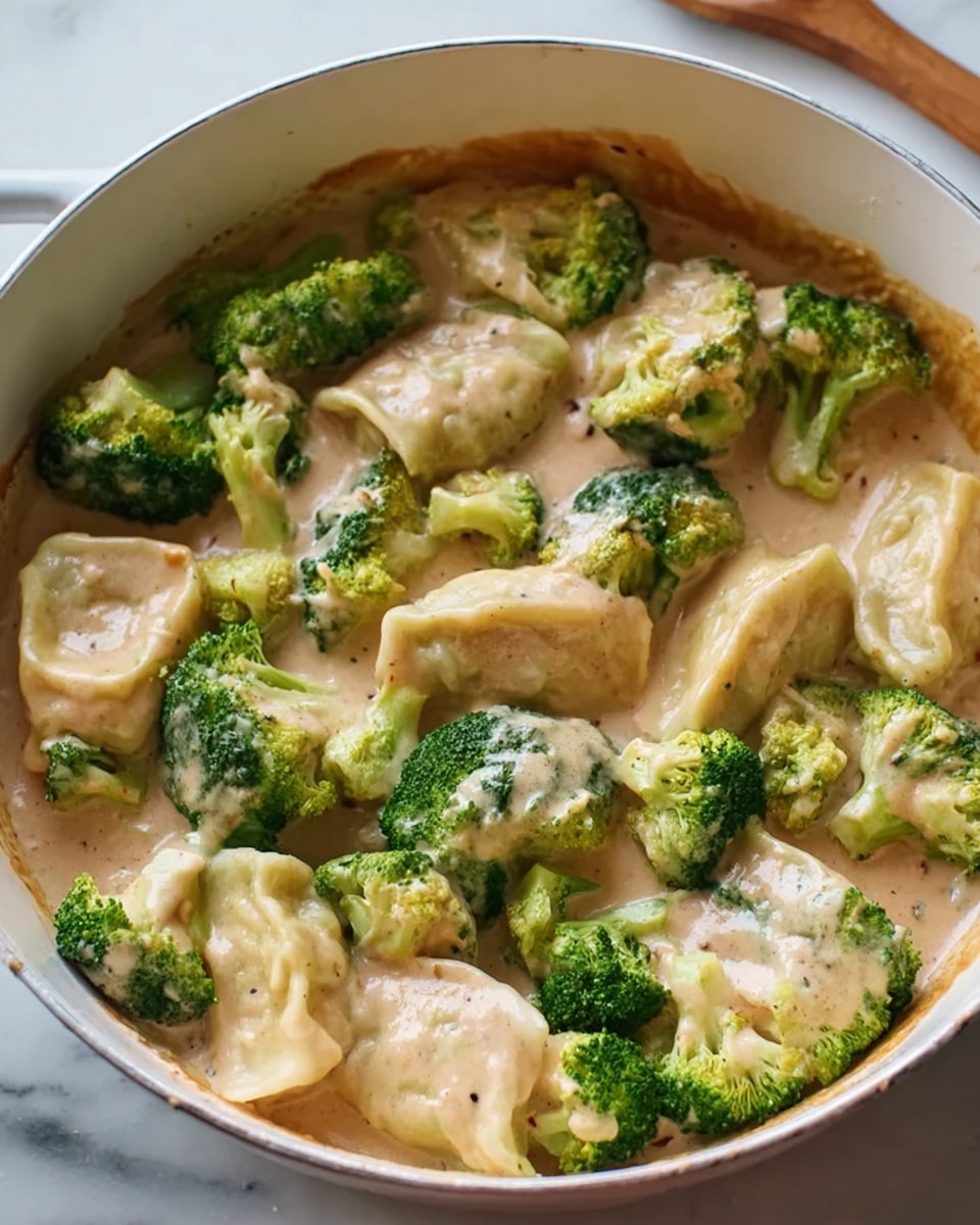 The image shows a white pot filled with bright green broccoli pieces covered in a thick, light brown creamy sauce. The broccoli is scattered evenly throughout, with some pieces mostly dipped in the sauce while others sit lightly covered on top. The sauce has a smooth texture with small visible specks inside, giving it a speckled look. The pot rests on a white marbled surface, and a wooden spoon is partially visible on the right side above the pot. The scene hints at a warm, comforting dish being prepared. Photo taken with an iphone --ar 4:5 --v 7