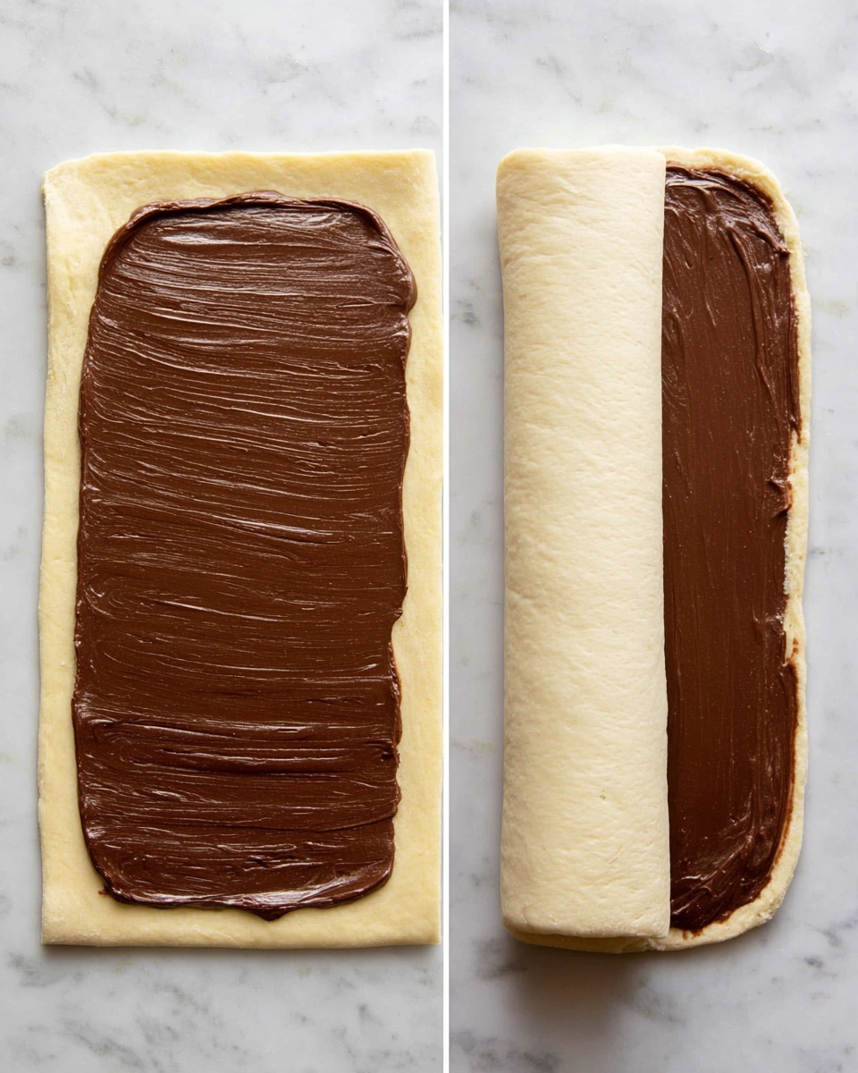 Nutella Braided Bread with Simple Syrup Recipe 4 The image shows two stages of making a rolled dessert on a white marbled surface. On the left, there is a flat, rectangular layer of pale dough with smooth, thick, dark brown chocolate spread evenly covering its surface, leaving a narrow border of dough visible. On the right, the dough is being rolled tightly from the bottom edge up, partly covering the chocolate layer with the pale dough forming the outer layer and the rich chocolate visible inside the roll. Both images highlight the smooth texture of the chocolate and the soft, slightly bumpy dough. Photo taken with an iphone --ar 4:5 --v 7