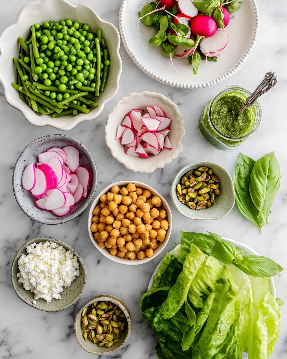 The image shows an arrangement of fresh salad ingredients on a white marbled surface. There are nine different layers: at the top center is a white bowl filled with chopped green asparagus, and below it to the left is a white scalloped plate with bright green peas. Near the middle right, there's a small white bowl with sliced red and white radishes, and next to it on the far right is a small white bowl with green pistachios. Below the radishes is a larger white bowl of golden roasted chickpeas. To the left bottom corner is a grayish bowl with crumbly white feta cheese. Next to it is a white plate with thin slices of pink and white watermelon radish. In the center bottom is a bunch of fresh green basil leaves, and to the right of it are large green butter lettuce leaves. Above the pistachios, a small glass jar containing a green herb dressing with a silver spoon inside completes the setup. Photo taken with an iphone --ar 4:5 --v 7