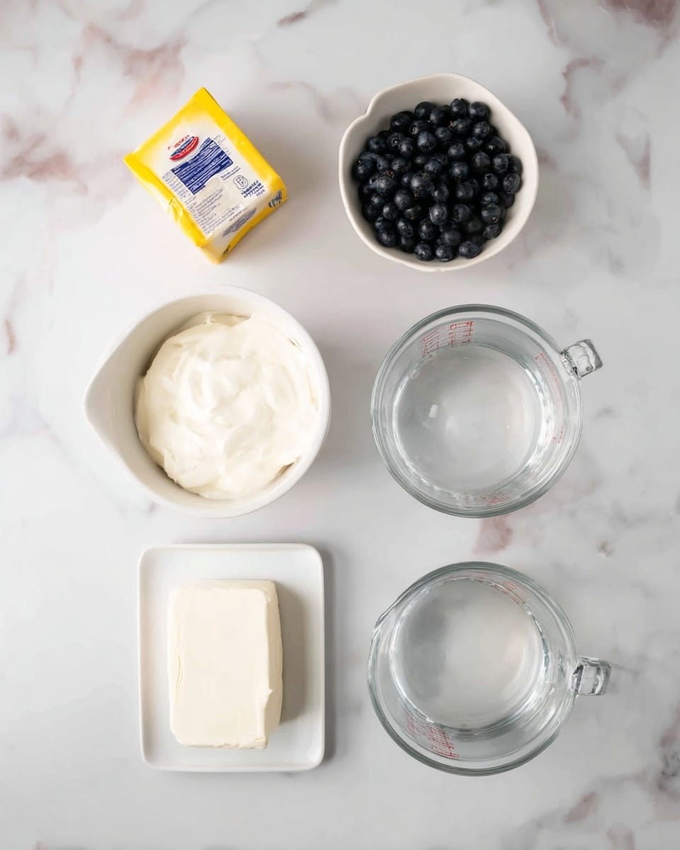 The image shows six items arranged neatly on a white marbled surface. At the top left, there is a small yellow and white box, with a blue and red label. At the top right, there is a small white bowl filled with dark blue round blueberries. In the center, there is a medium white bowl filled with thick white cream. Below, there are two clear glass measuring cups filled with water; the left one is slightly fuller than the right one. At the bottom center, there is a small white rectangular dish holding a solid block of white cream cheese. Photo taken with an iphone --ar 4:5 --v 7