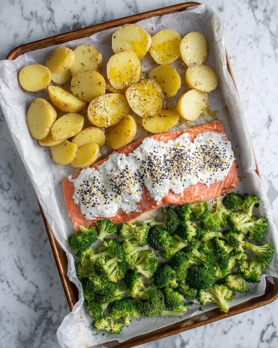 The image shows a baking tray lined with white parchment paper holding a meal ready to cook. The tray has three sections: the top part contains thick, round slices of yellow potatoes seasoned with black pepper and a drizzle of oil, the center right part holds a large piece of raw salmon fillet topped with a thick, white creamy spread and sprinkled with black and white sesame seeds and other spices, and the bottom part features fresh, bright green broccoli florets scattered loosely. The tray is set on a white marbled surface. photo taken with an iphone --ar 4:5 --v 7
