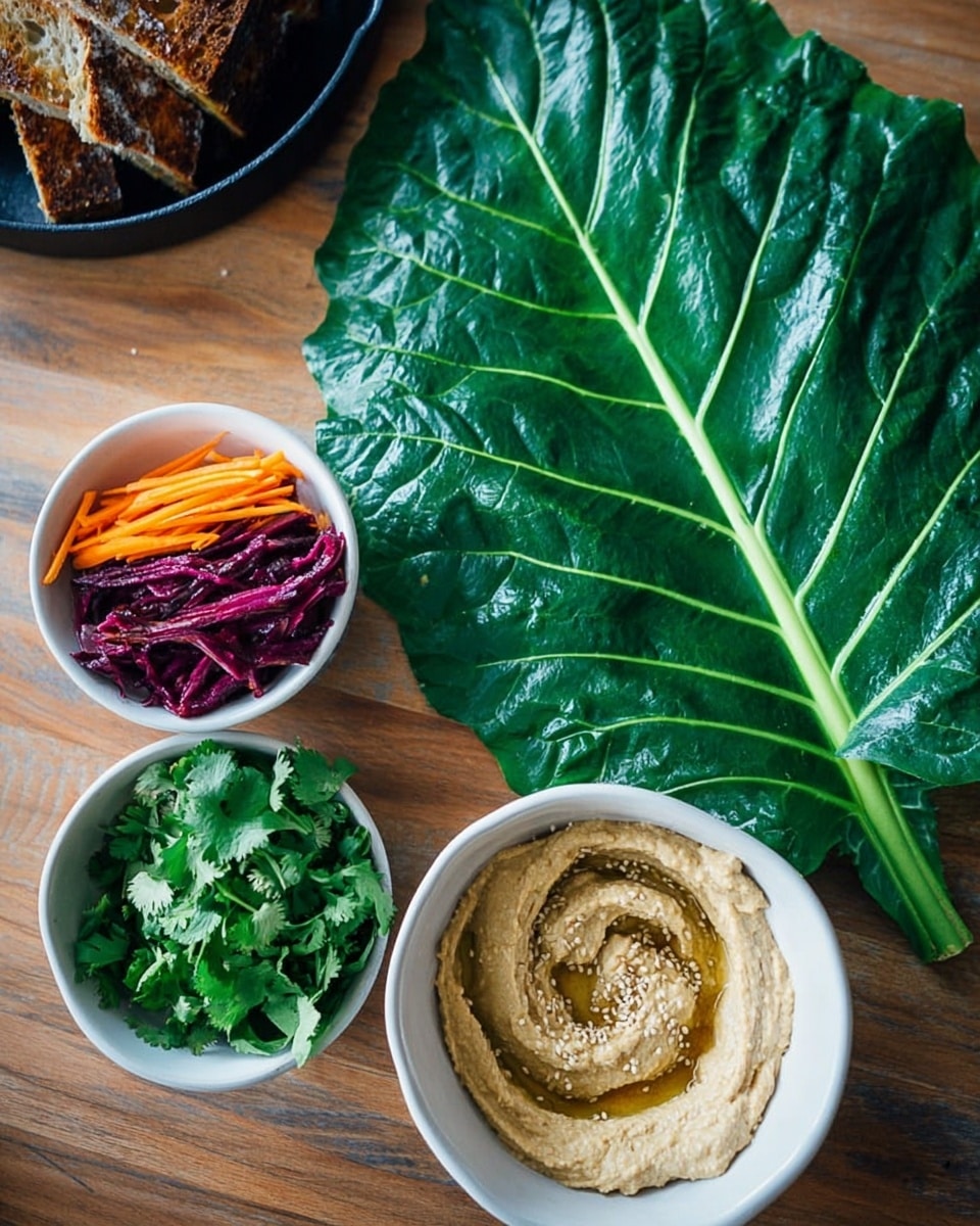 A large shiny green leaf is placed flat on a wooden surface, showing clear veins and a thick stem in the center. Next to the leaf are two white bowls; the top one contains three separate layers of ingredients – bright orange thin strips, dark purple thin strips, and fresh green cilantro leaves, all neatly arranged side by side. The bottom bowl holds light beige creamy hummus with small sesame seeds sprinkled on top and a smooth swirl pattern in the middle. A black cast iron pan with some pieces of toasted bread is slightly visible in the background. Photo taken with an iphone --ar 4:5 --v 7