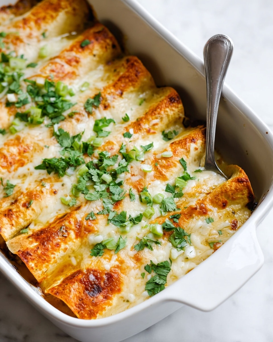In a white rectangular baking dish, there are three rolled pieces of pale yellow tortillas with lightly browned edges. The tortillas are covered in a creamy white sauce and melted cheese that has some golden brown spots from baking. On top, bright green chopped herbs and small sprigs of cilantro are scattered, adding fresh color. A silver spatula is lifting one end of the first roll, revealing the texture of the soft sauce and cheese. The baking dish is placed on a white marbled surface with a gray cloth nearby. Photo taken with an iphone --ar 4:5 --v 7