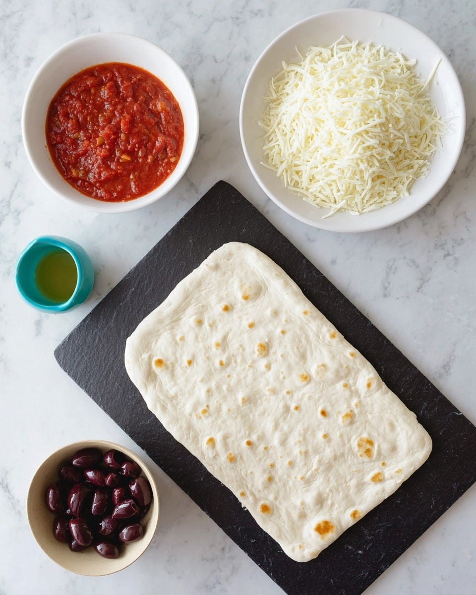 The image shows a flat rectangular white pizza dough placed on a dark slate serving board, with small dimples and light golden spots on the dough surface. Above the dough, there is a white round plate filled with white shredded cheese, showing thin curly strands. To the left, there is a white bowl with bright red tomato sauce that has small green herb bits visible in the sauce. Below that, a light beige round bowl holds dark purple kalamata olives, glossy and smooth. In the bottom left corner, a small turquoise cup holds a light green liquid, likely olive oil. All items are arranged on a white marbled surface. Photo taken with an iphone --ar 4:5 --v 7