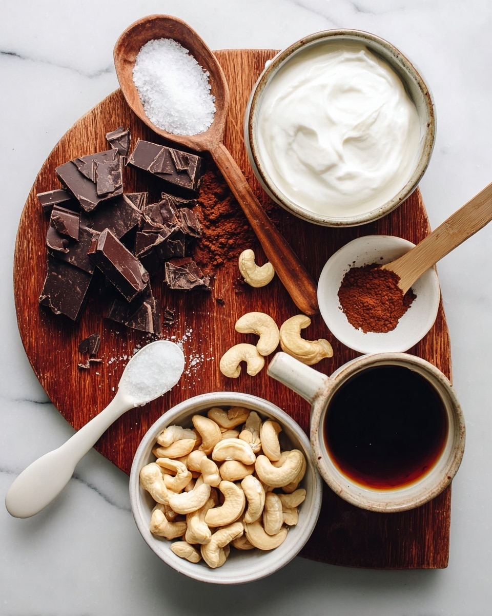 The image shows a wooden board on a white marbled surface. On the board are chopped dark chocolate pieces and a wooden spoon holding white salt. Nearby, a small white bowl with brown cocoa powder and a white spoon with dark liquid rest on the board. Surrounding the board are three bowls: one filled with light beige cashew nuts, another with thick white coconut cream, and a white cup holding dark coffee. All items are neatly arranged for a cooking setup photo taken with an iphone --ar 4:5 --v 7