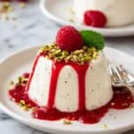 Silky Vanilla Panna Cotta with Raspberry Coulis and Pistachio Garnish Recipe