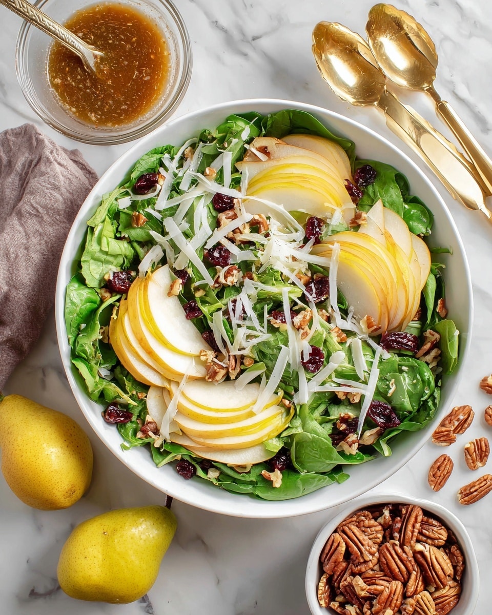 The image shows a fresh salad in a white bowl placed on a white marbled surface. The salad has several layers starting with a base of mixed green leafy vegetables with various shapes and shades of green. On top, there are yellow slices of pear layered around the bowl. Alongside the pears, there are curly white onion rings spread evenly. Scattered throughout are brown pecan halves, small red dried cranberries, and thin white cheese shavings. A golden serving tong rests on the edge of the bowl, partially inside the salad. The scene is bright and fresh, with soft natural lighting. Photo taken with an iphone --ar 4:5 --v 7