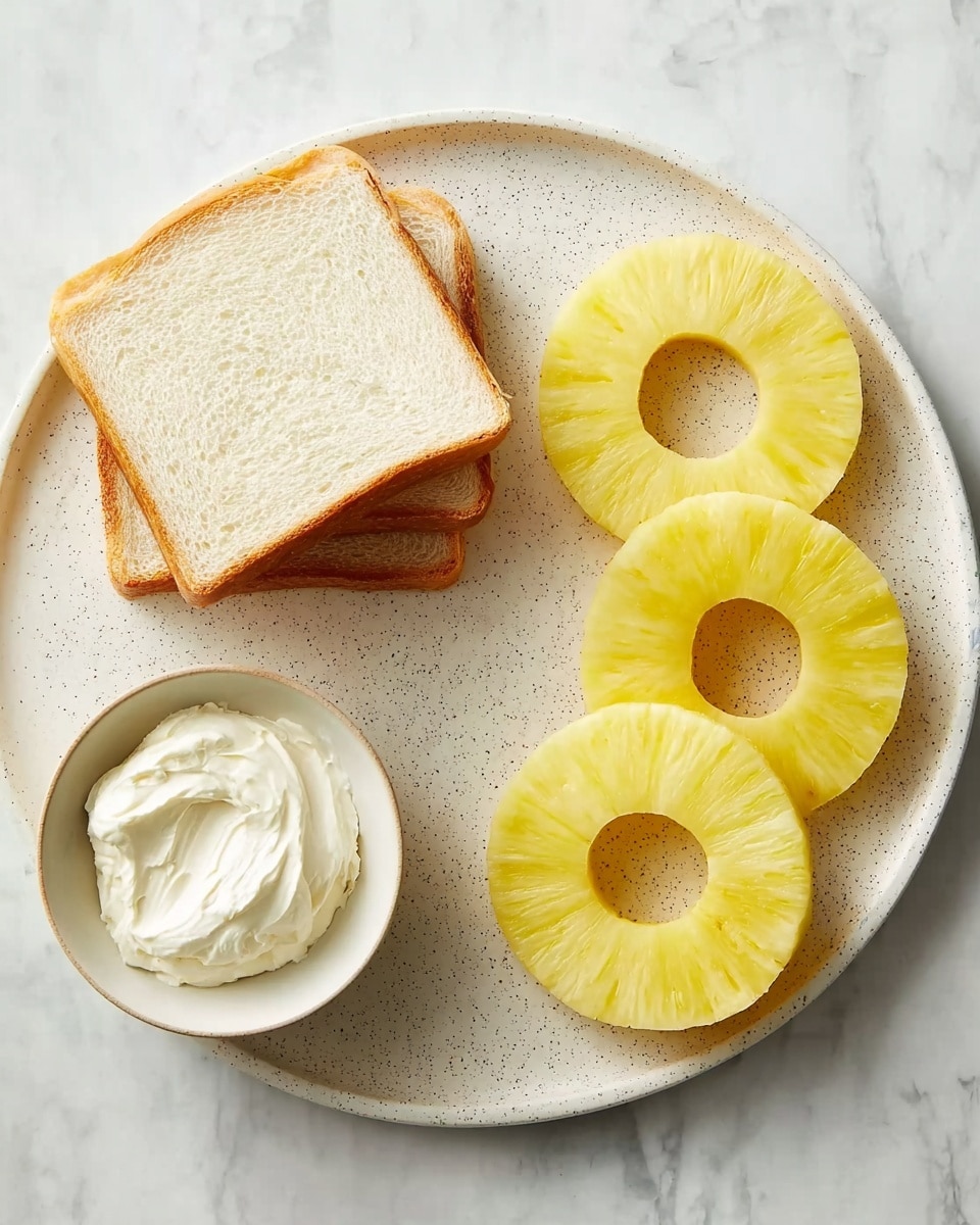 The image shows four bright yellow pineapple rings with a smooth texture placed evenly on a white speckled plate on the right side. On the left side, there are two slices of white bread stacked together with a light brown crust. Below the bread, a small white bowl holds a creamy white spread with a smooth and soft texture. Everything is arranged on a white marbled surface, giving a fresh, clean look. photo taken with an iphone --ar 4:5 --v 7
