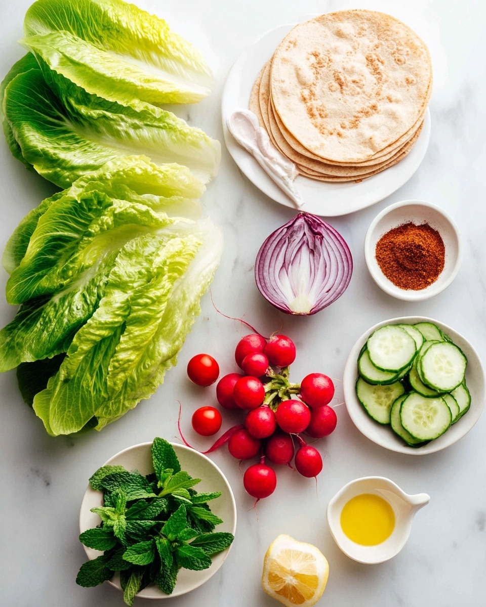 The image shows a fresh and colorful arrangement of ingredients on a white marbled surface. On the left, there are large green lettuce leaves layered vertically. To the right of the lettuce, a group of small red cherry tomatoes is scattered in a loose cluster. Below the tomatoes, several bright red radishes are gathered together. Next to the radishes, a small pile of thinly sliced cucumber rounds is stacked neatly. At the top, a purple onion is cut in half with its inner white and purple rings visible. To the right side, a white bowl filled with a reddish-brown spice powder has a white spoon resting in it. Nearby, a stack of three round, light golden flatbreads rests side by side on a white plate. At the bottom, a small white round plate holds fresh green mint sprigs, two white garlic cloves, half a lemon, and a small bowl of yellow olive oil. The colors are bright and fresh, and the arrangement is clean and orderly, suggesting preparation for a fresh vegetable dish photo taken with an iphone --ar 4:5 --v 7