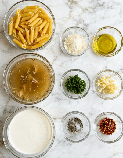 The image shows nine small clear glass bowls arranged neatly on a white marbled surface. The largest bowls contain yellow penne pasta at the top left, a golden light brown chicken broth below it, and creamy white heavy cream below that. To the right, from top to bottom, are smaller bowls with grated white parmesan cheese, bright yellow olive oil, chopped green parsley, minced pale yellow garlic, and a final bowl with mixed black and white salt and pepper. Each bowl is clearly labeled with dark gray tags indicating its contents. photo taken with an iphone --ar 4:5 --v 7